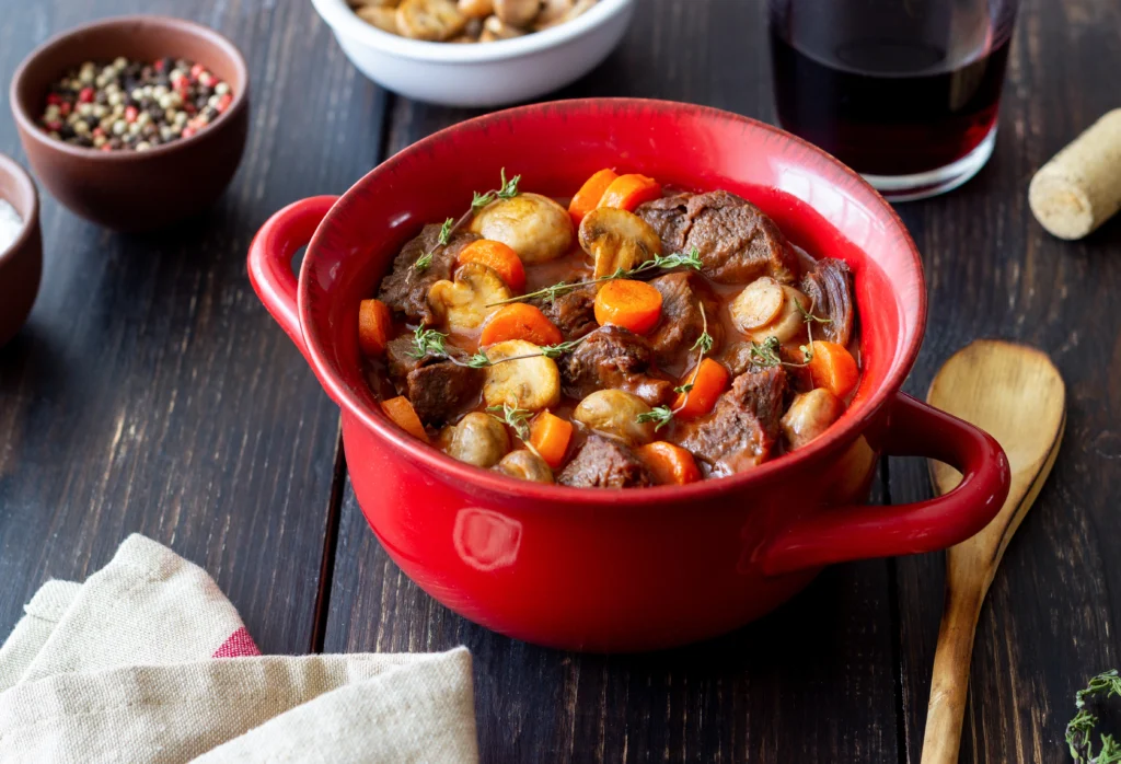 A bowl of hearty old-fashioned vegetable beef soup with tender beef, carrots, potatoes, and fresh herbs in a rich savory broth.